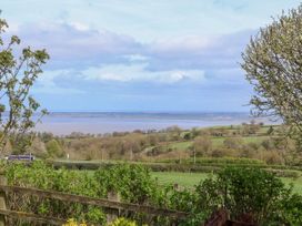 A countryside view with green fields trees and a body of water in the distance at Dolphin Bach in Dolphin