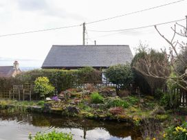 A garden with a pond surrounded by plants and flowers with a house in the background at Dolphin Bach in Dolphin
