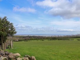 A landscape with grassy fields trees hedges and a partly cloudy sky at Dolphin Bach in Dolphin