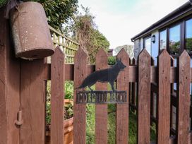 A brown wooden picket fence with a metal dog silhouette and dolphin bach sign at Dolphin Bach in Dolphin