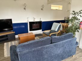 A living room with a television, sofa, and coffee table at Lighthouse Cottage in St Erme near Truro