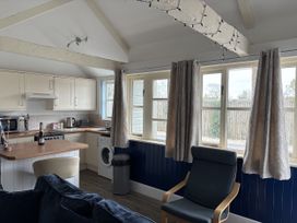 A kitchen with appliances and seating at Lighthouse Cottage in St Erme near Truro