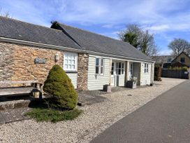 A house with a stone wall and bench at Lighthouse Cottage St Erme near Truro
