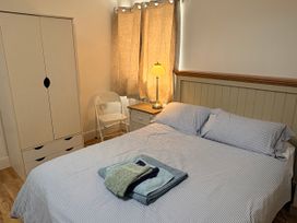 A bedroom with a bed and wardrobe at Lighthouse Cottage St Erme near Truro