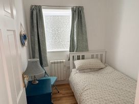 A bedroom with a bed and lamp at Lighthouse Cottage in St Erme near Truro