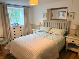 A bedroom with a bed and nightstand at Sunlight Cottage St Erme near Truro