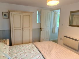 A bedroom with a bed and wardrobe at Sunlight Cottage St Erme near Truro