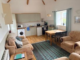 A kitchen and living area with seating and dining table at Sunlight Cottage in St Erme near Truro