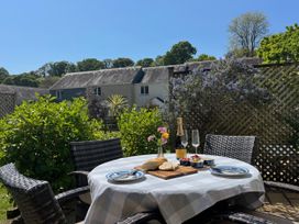 An outdoor dining area with a table set for a meal at Breeze Cottage in Falmouth