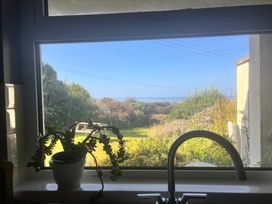 A kitchen view with a sink and plant overlooking a garden at Merriview Ashton Nr Helston