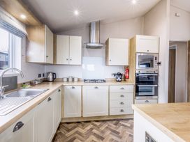 A kitchen with cabinets and appliances at Lodge 66 at Riviera Bay Coastal Retreat Brixham