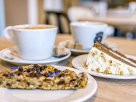 A coffee cup, a slice of cake, and a cookie at Lodge 74 at Riviera Bay Coastal Retreat in Brixham