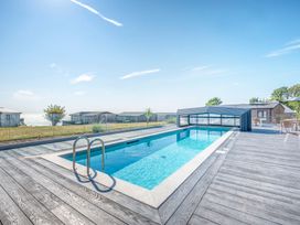 An outdoor area with a swimming pool and decking at Lodge 74 at Riviera Bay Coastal Retreat in Brixham