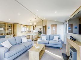 A living room with a sofa and kitchen area at Lodge 55 at Riviera Bay Coastal Retreat in Brixham