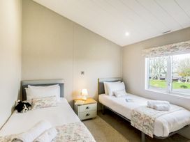 A bedroom with two beds and a window at Lodge 55 at Riviera Bay Coastal Retreat Brixham