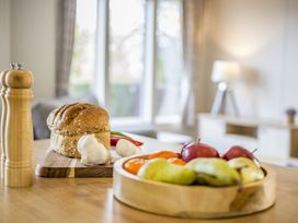 A kitchen with bread, garlic, and fruits on a table at Lodge 58 at Riviera Bay Coastal Retreat in Brixham