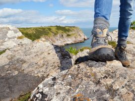 A person standing on rocks next to water at Lodge 58 at Riviera Bay Coastal Retreat in Brixham