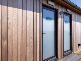 Two doors with signs on a wooden wall at Lodge 59 at Riviera Bay Coastal Retreat Brixham