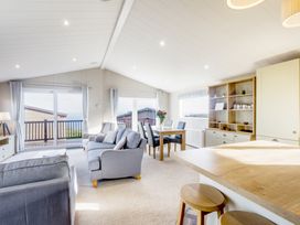 A living room with a sofa and dining area at Lodge 63 at Riviera Bay Coastal Retreat Brixham