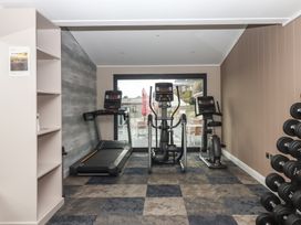 A gym with a treadmill, elliptical machine, and exercise bike at Lodge 71 at Riviera Bay Coastal Retreat Brixham