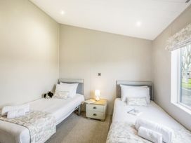 A bedroom with two single beds and a lamp at Lodge 64 at Riviera Bay Coastal Retreat in Brixham
