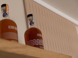 Two bottles of Devon rum on a wooden shelf at Lodge 73 at Riviera Bay Coastal Retreat Brixham
