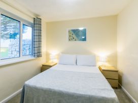 A bedroom with a bed and bedside tables at Chalet 31 at Landscove Holiday Park Brixham