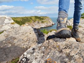 A person standing on a rock near water at Chalet 38 at Landscove Holiday Park Brixham