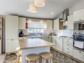 A kitchen with cabinets and appliances at Lodge 15 at Landscove Holiday Park in Brixham