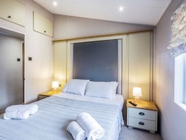 A bedroom with a bed and bedside table at Lodge 15 at Landscove Holiday Park Brixham