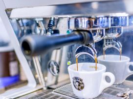 An espresso machine brewing coffee into a cup at Lodge 9 at Landscove Holiday Park Brixham