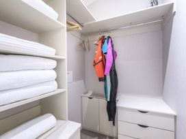 A storage room with shelves and wetsuits at Lodge 11 at Landscove Holiday Park, Brixham