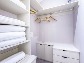 A closet with shelves, towels, and hangers at Lodge 11 at Landscove Holiday Park Brixham