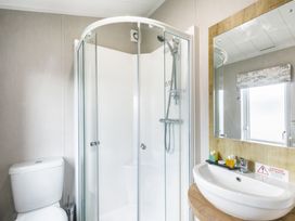 A bathroom with a shower and a sink at Lodge 11 at Landscove Holiday Park Brixham