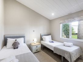 A bedroom with two single beds and a bedside table at Lodge 11 at Landscove Holiday Park Brixham