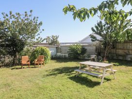 A garden with a picnic table and wooden chairs at Bod A Quinte in Carbis Bay