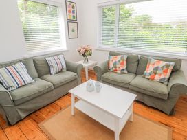 A living room with sofas, a coffee table and a vase of flowers at Bod A Quinte, Carbis Bay