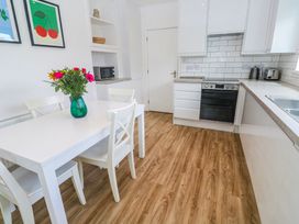 A kitchen with a table and chairs and a vase of flowers at Bod A Quinte, Carbis Bay
