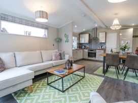 A living room with a sofa and coffee table next to a kitchen and dining table at Wurzburc in Swaffham