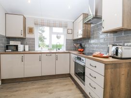 A kitchen with cabinets a microwave toaster kettle and oven at Wurzburc in Swaffham