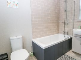 A bathroom with a toilet bathtub shower and sink at Wurzburc in Swaffham