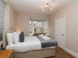 A bedroom with a bed pillows folded towels window and wooden floor at Metcalfe House Compton Dundon