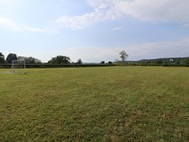 An open grass field with goal posts and a basketball hoop at Metcalfe House Compton Dundon