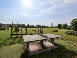 A table tennis table near play structures and picnic tables in an outdoor area at Metcalfe House Compton Dundon