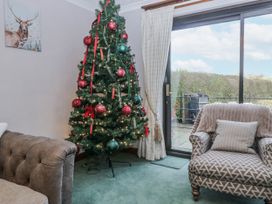 A living room with a Christmas tree and a sliding door at 1 Gilpin House Levens
