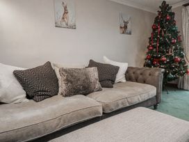 A living room with a sofa and Christmas tree at 1 Gilpin House Levens