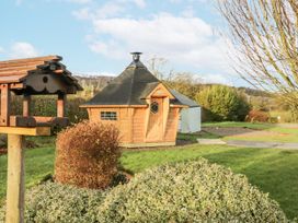 A garden with a wooden shed and a birdhouse at 1 Gilpin House Levens