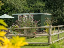 A shepherd's hut and garden with flowers at Collen in Aberaeron