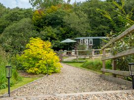 A gravel path leading to a green shack with an umbrella at Collen in Aberaeron