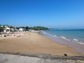 A beach with people and buildings in the background at 15 Lawnswood in Saundersfoot